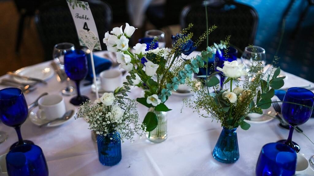 Reception table with cobalt glassware and bud vases