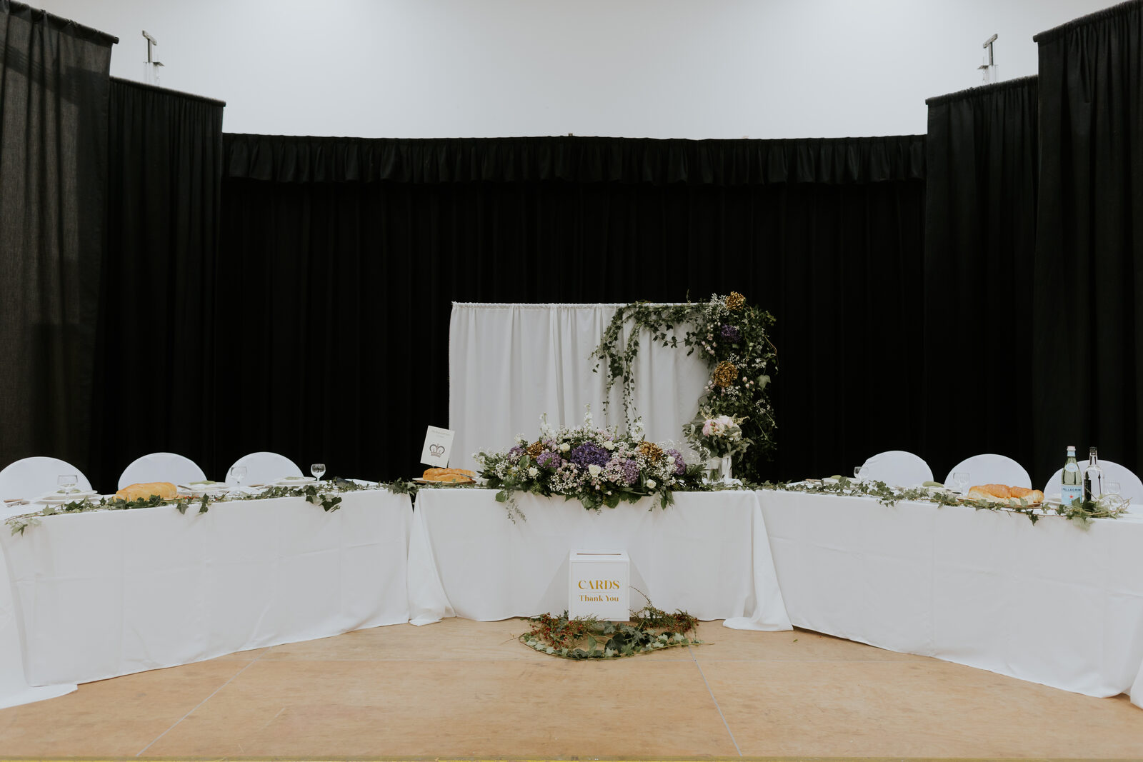Head table florals against a dark drape